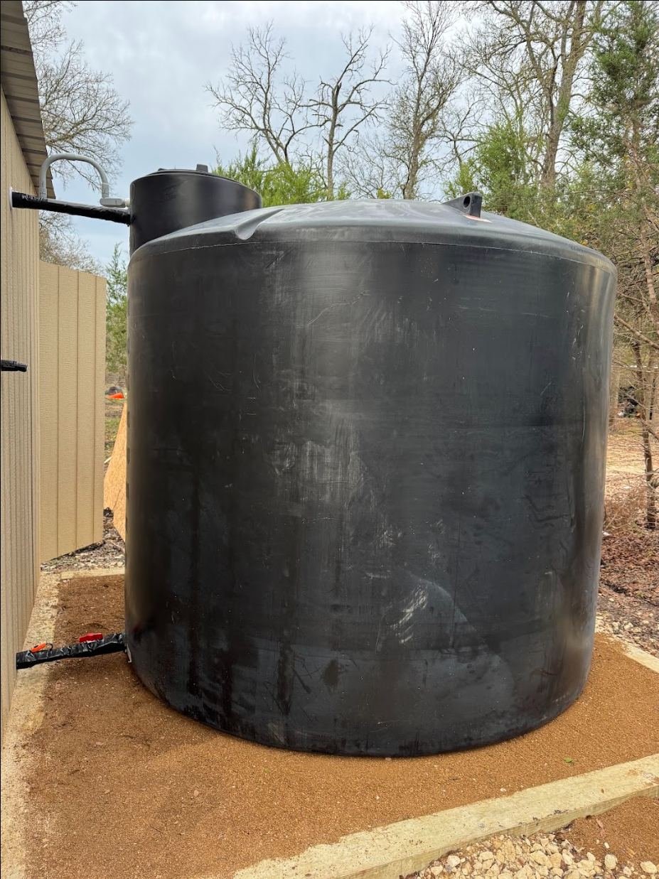 2,500-gallon black water storage tank on a framed crushed granite pad on a wooded lot in Central Texas