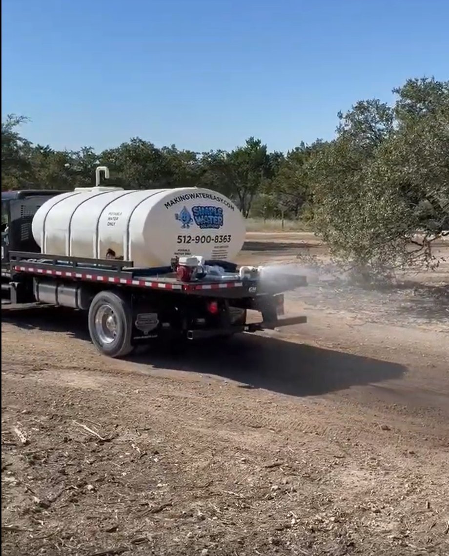 Dirt road dust control - dry caliche ahead of the truck, wet and settled behind