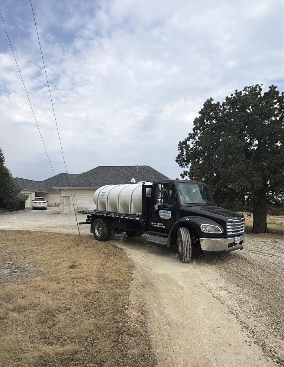 Water truck on a private gravel road near Liberty Hill after a dust control pass