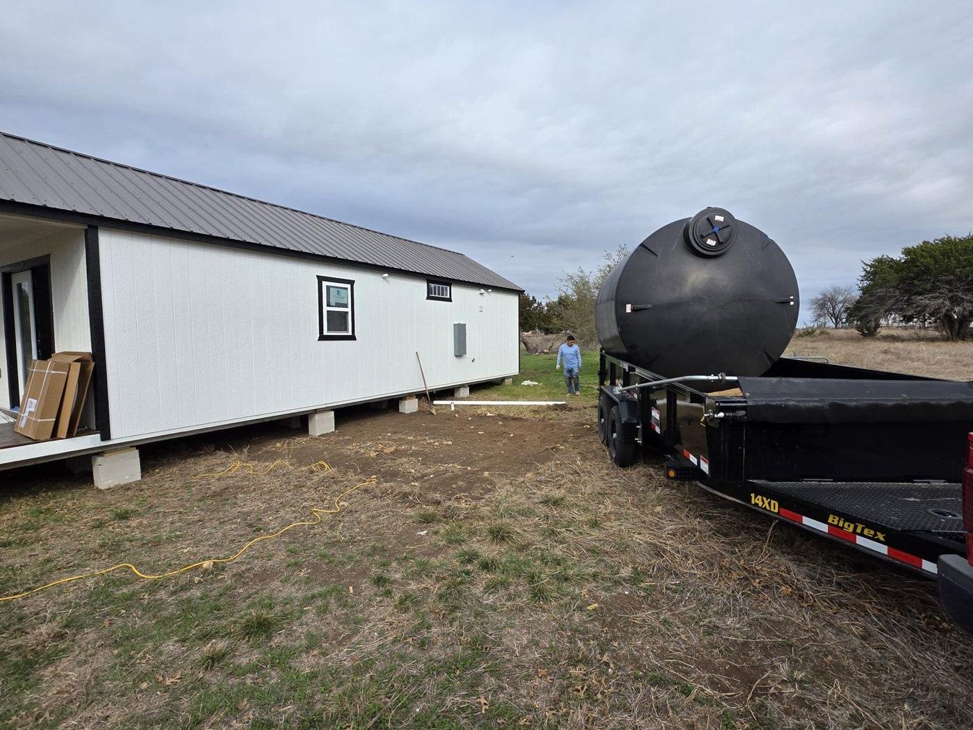 2,500-gallon water storage tank arriving by trailer for installation on Central Texas acreage